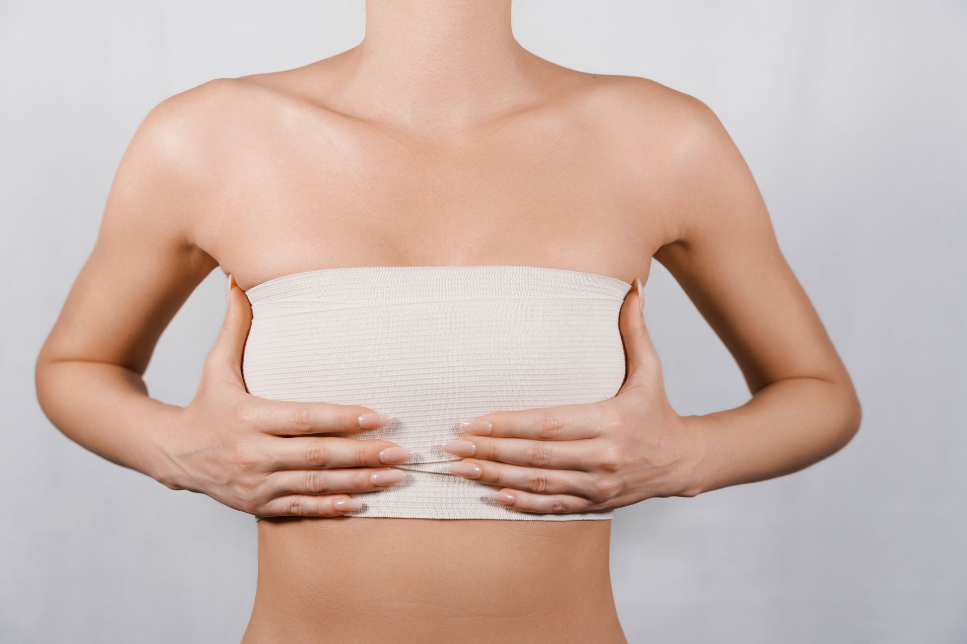 A person performs a breast self-exam, using their hands to examine the tissue for changes.