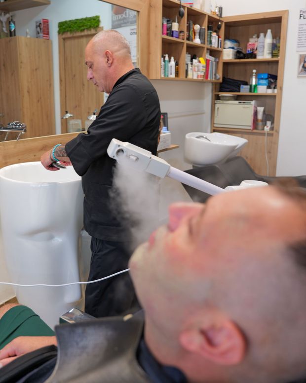 Primo piano di una rifinitura della barba con le forbici in un negozio di barbiere.