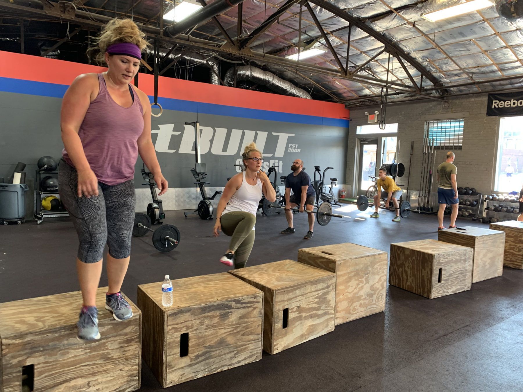 A group of people are doing exercises in a gym.