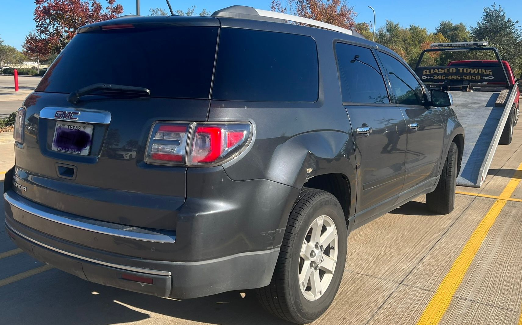 Gray SUV parked in a handicap parking spot at a lot, with a wheelchair-accessible sign nearby.