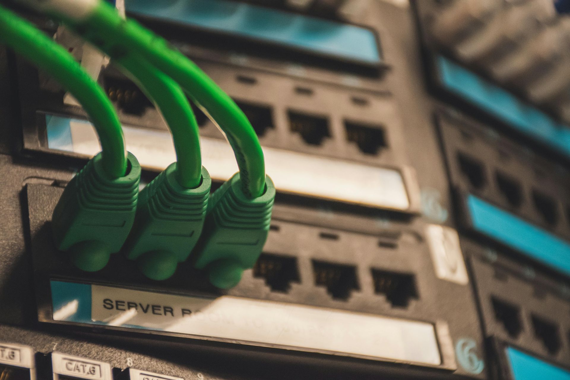 A bunch of green cables are connected to a server.