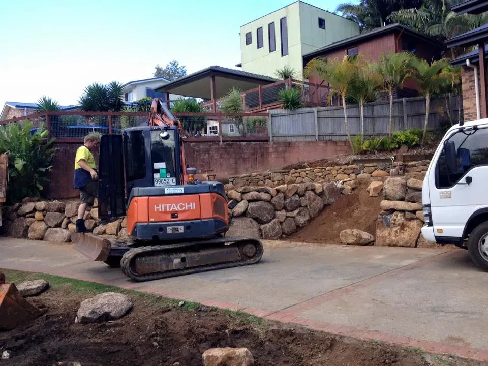 Red Excavator On A Sloped Driveway — Border Rockwalls in Stotts Creek, NSW
