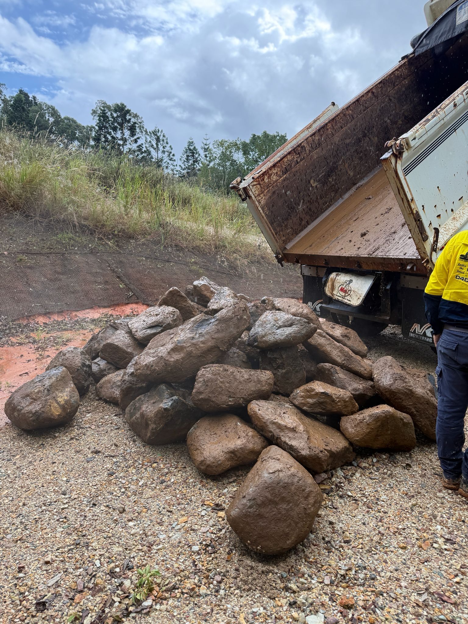 Dump Truck Unloading Large Rocks Onto a Gravel Road — Border Rockwalls in Stotts Creek, NSW