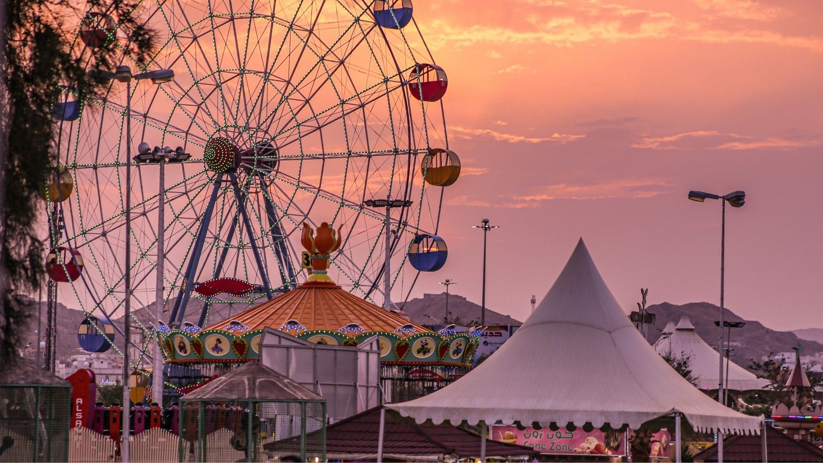 Ferris wheel and midway at a county fair at sunset