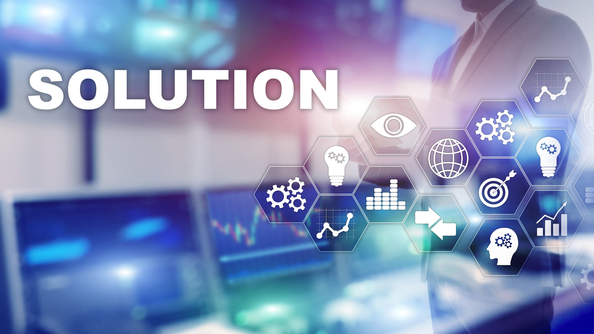 A man in a suit is standing in front of a computer screen with the word solution on it.
