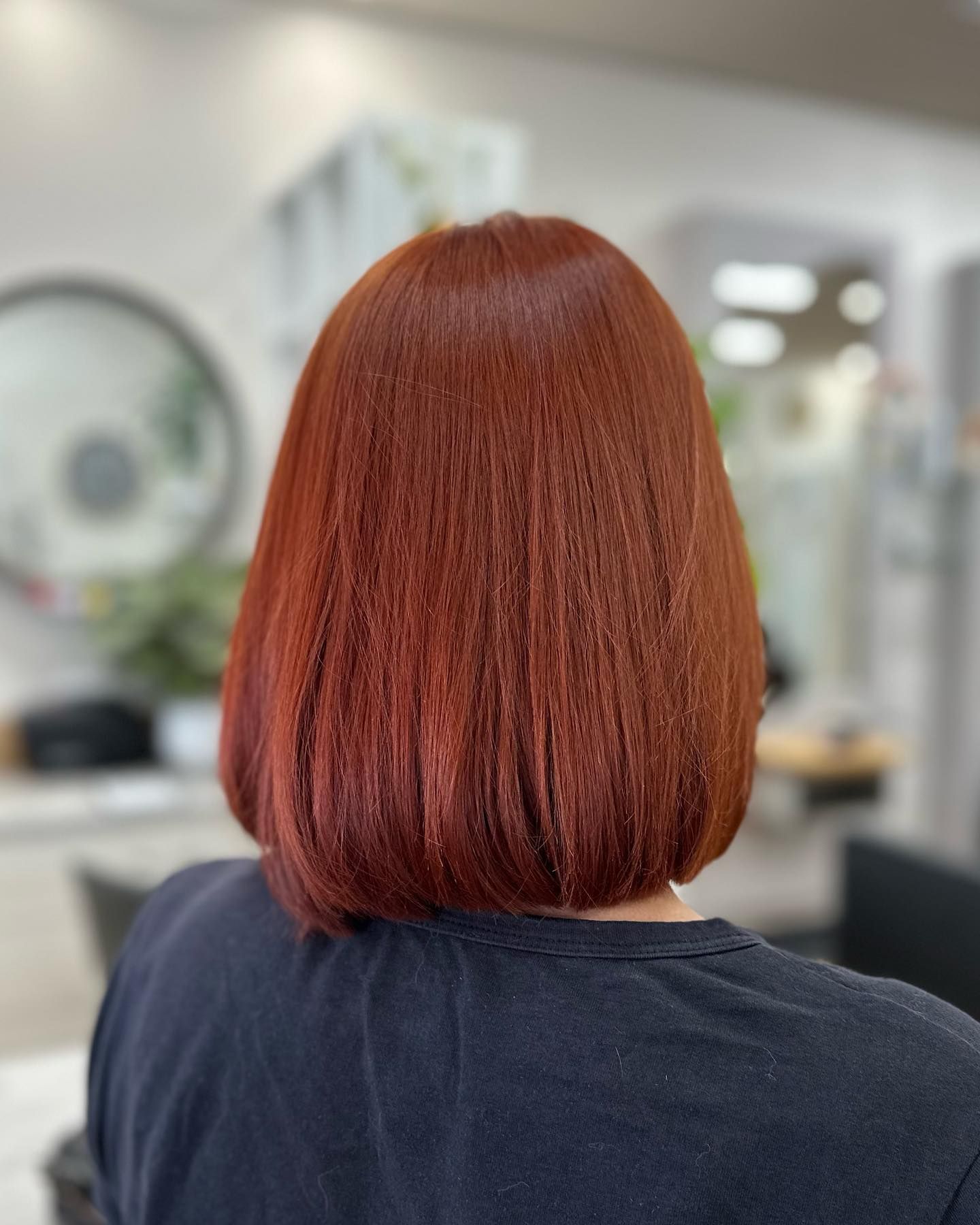 Back of a short, straight copper-red bob haircut in a salon mirror view — Hair to Impress In Lisarow, NSW