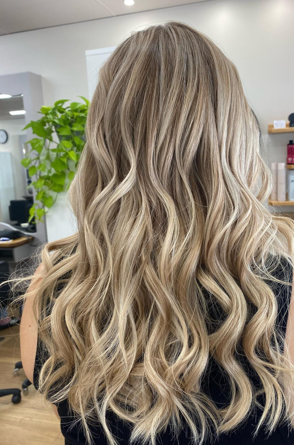 A Person With Long, Blonde, Wavy Hair Styled in a Salon — Hair to Impress In Lisarow, NSW