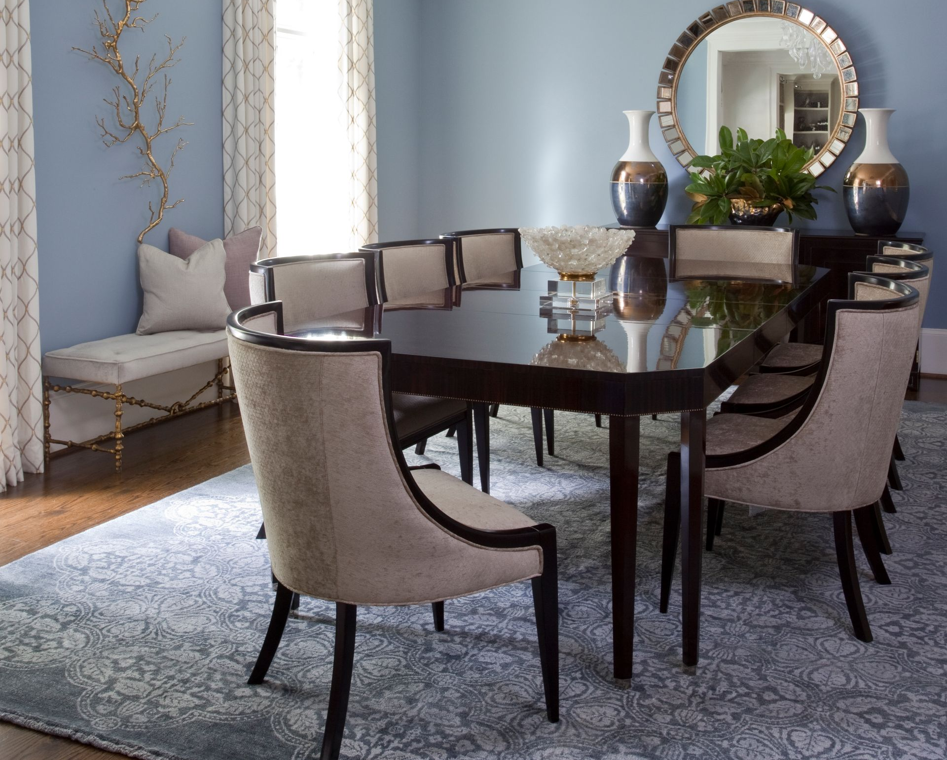 Elegant dining room with table, chairs, mirror, and decorative vases, set against a light blue wall.