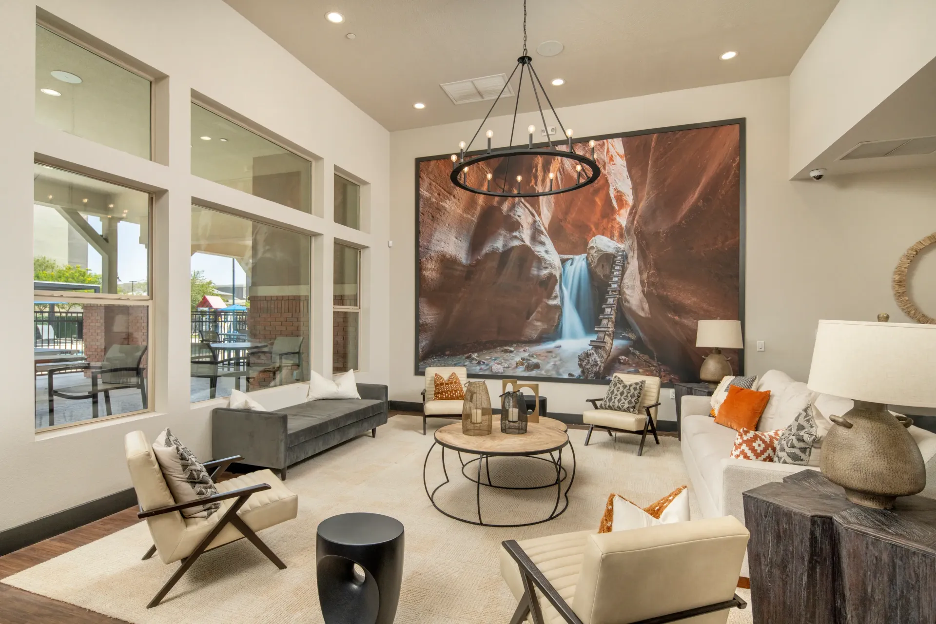 Lobby seating area with modern furniture and a large scenic mural.