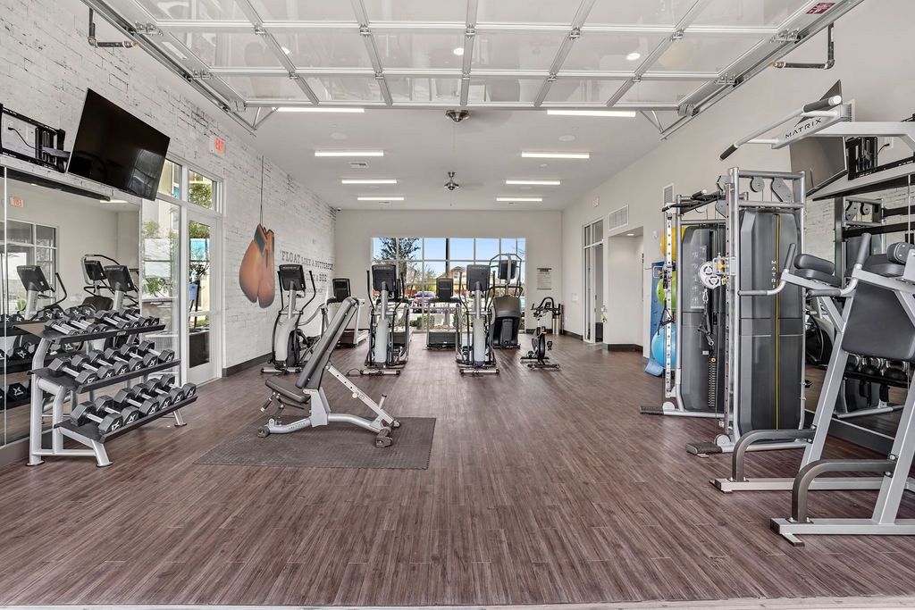 Interior fitness center with treadmills, weight machines, and free weights.