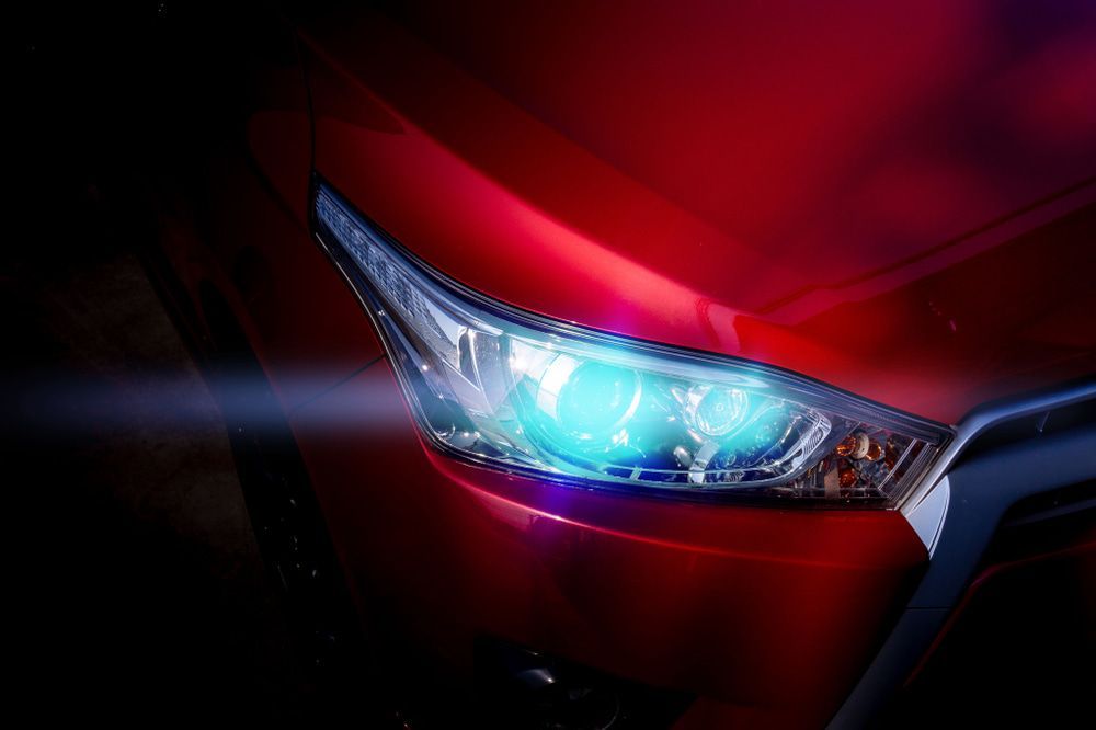 A Red Car's Front Headlight Shining Brightly — Norm Beatty's Auto Electrical Service In The Entrance, NSW