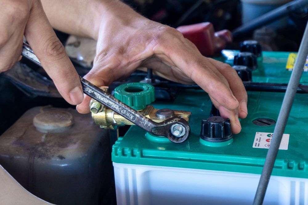 A Person Using a Wrench to Tighten a Battery Terminal — Norm Beatty's Auto Electrical Service In Long Jetty, NSW