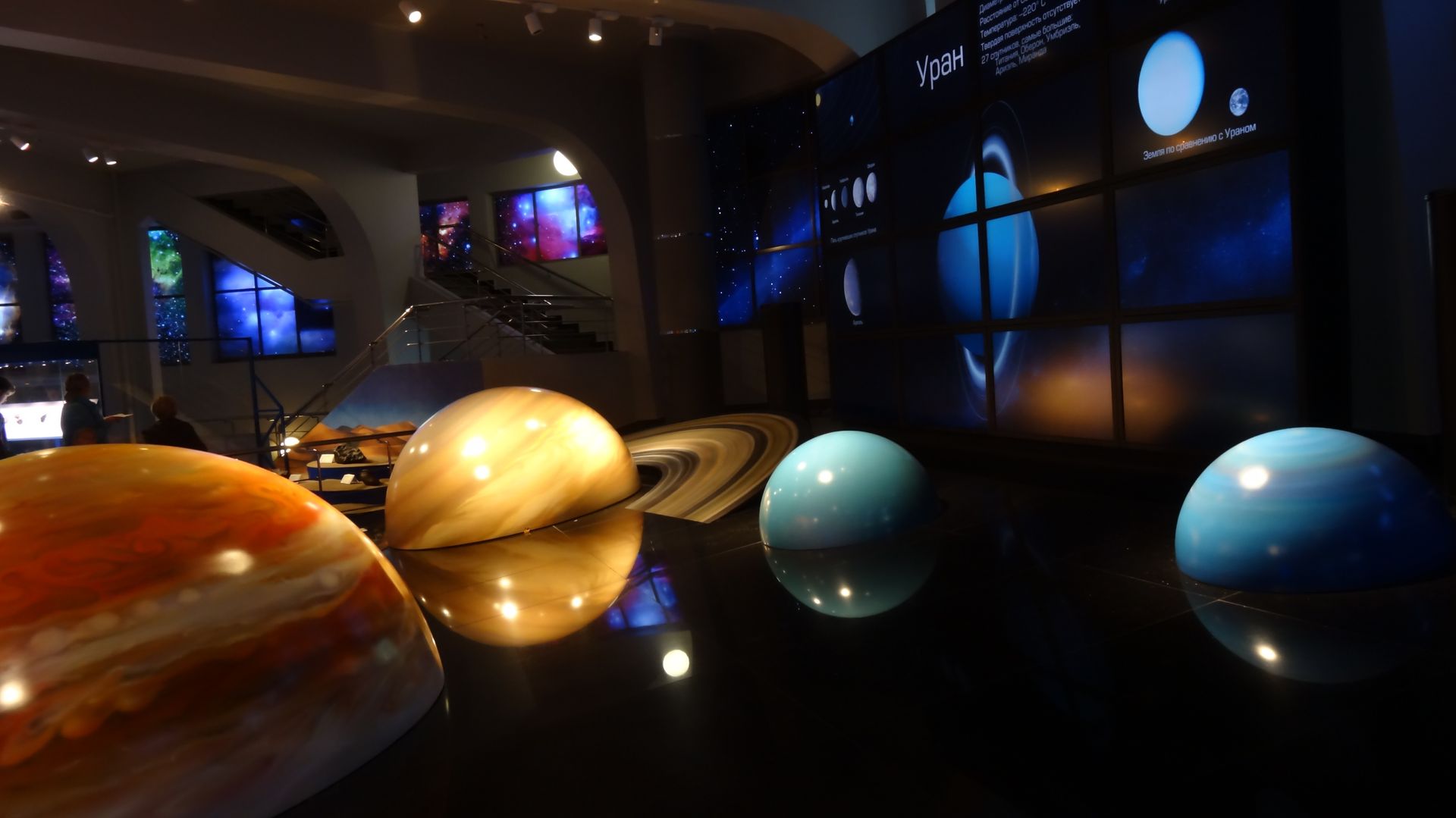 Large glowing planet models displayed in a dark museum exhibit