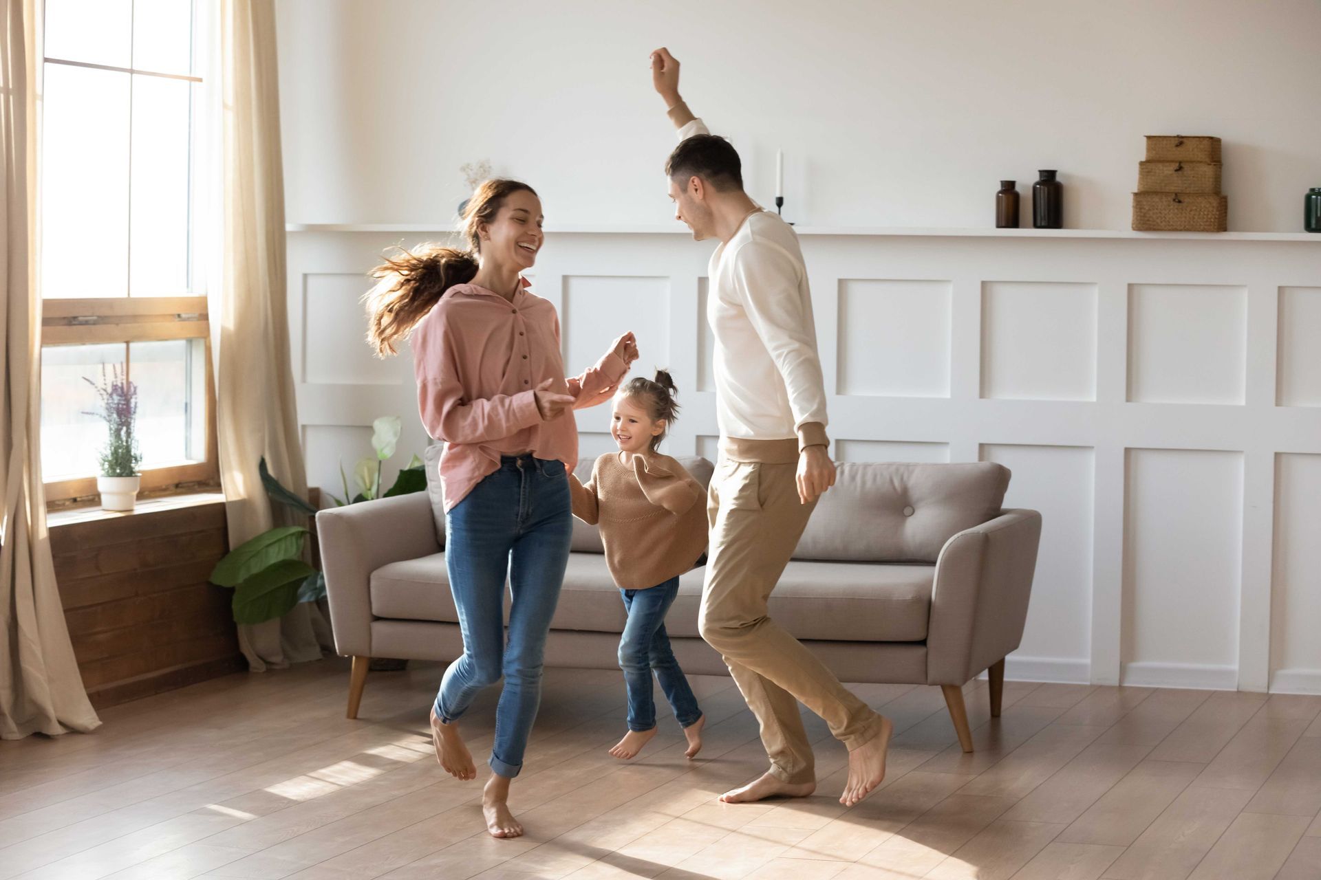 A family is dancing together in a living room
