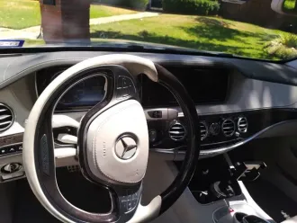 Mercedes-Benz car interior with steering wheel, dashboard, and center console in daylight