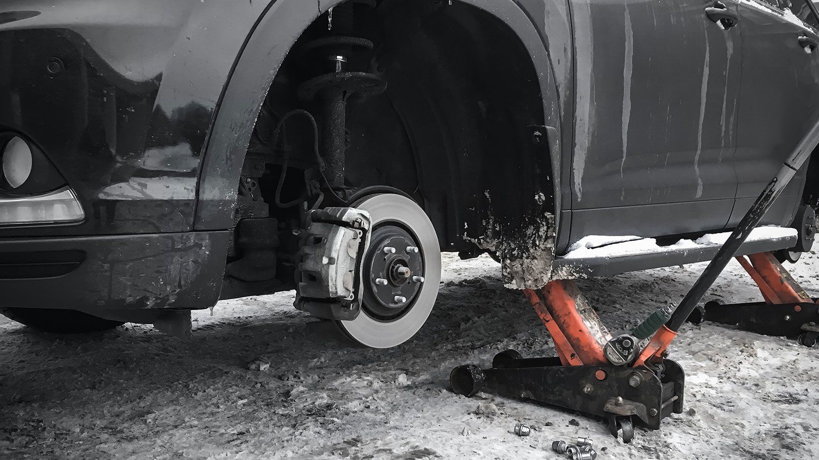 Un auto è ferma su un martinetto nella neve.
