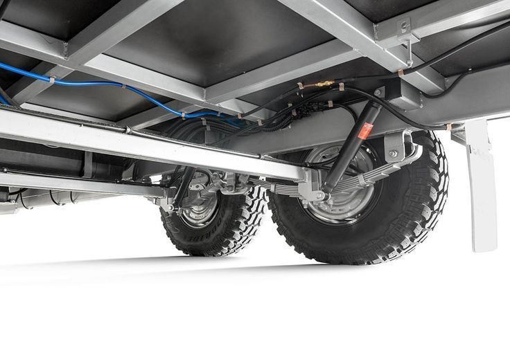 A close up of the underside of a trailer with a suspension system.