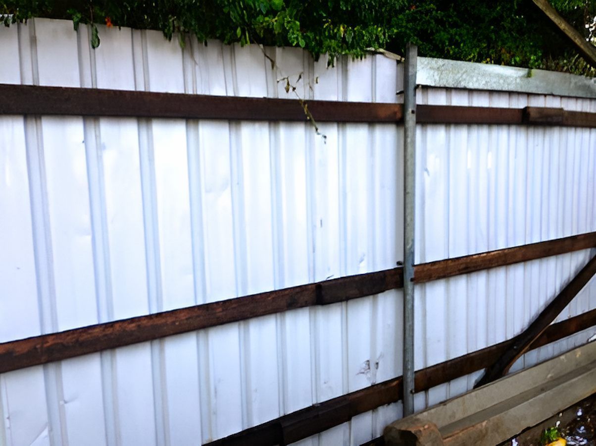 A White Fence With Wooden Beams Is Surrounded By Trees — EcoPro Pressure Cleaning In Broadbeach, QLD