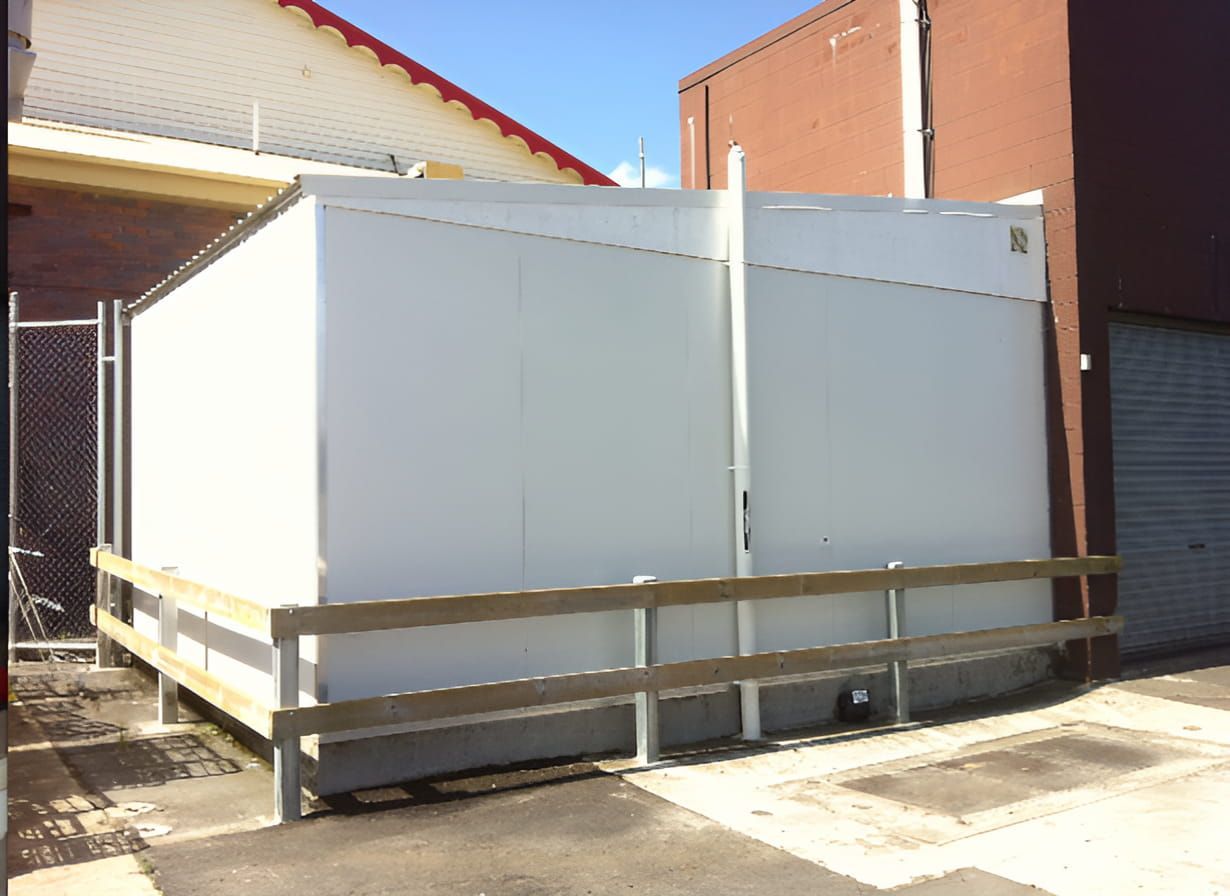 A White Building With A Wooden Fence Around It — EcoPro Pressure Cleaning In Broadbeach Waters, QLD