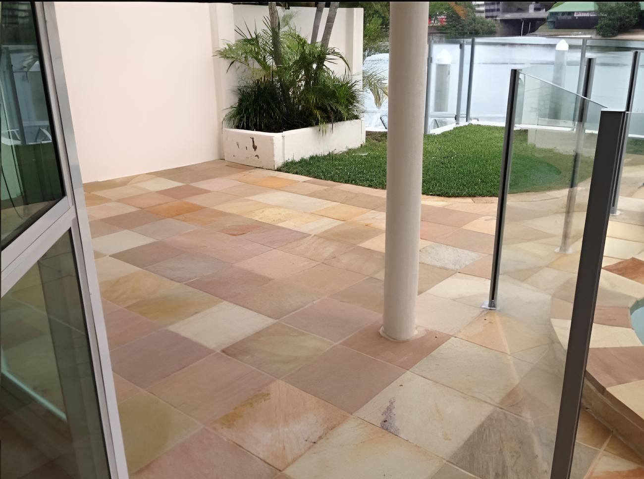 A Patio With Tiles And A Glass Railing Next To A Pool — EcoPro Pressure Cleaning In Broadbeach Waters, QLD