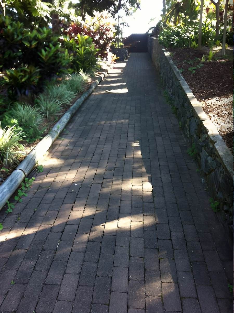 A Brick Walkway With A Car Parked On The Side Of It — EcoPro Pressure Cleaning In Broadbeach Waters, QLD