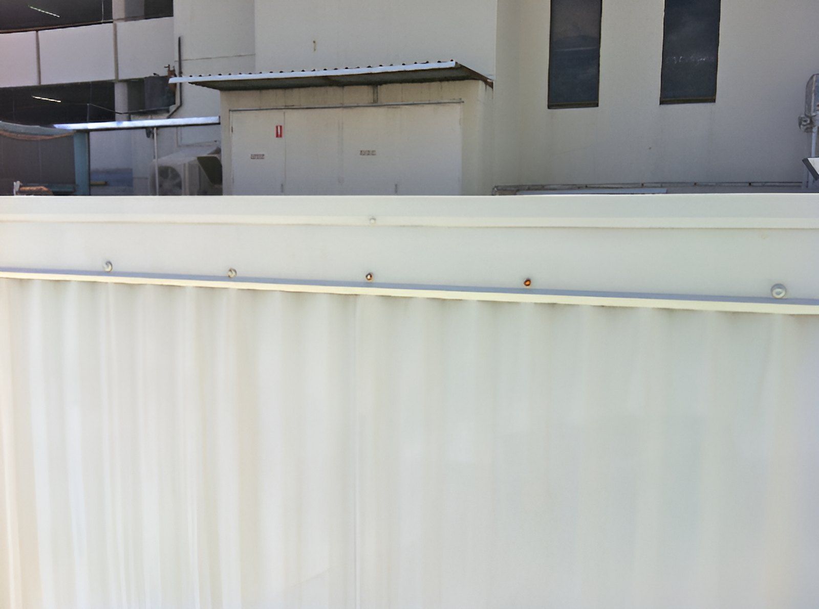 A White Fence Is In Front Of A White Building — EcoPro Pressure Cleaning In Broadbeach Waters, QLD