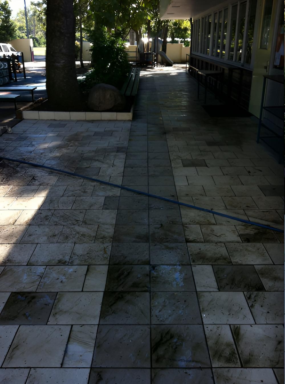 A Dirty Tiled Walkway Leading To A Building — EcoPro Pressure Cleaning In Robina, QLD
