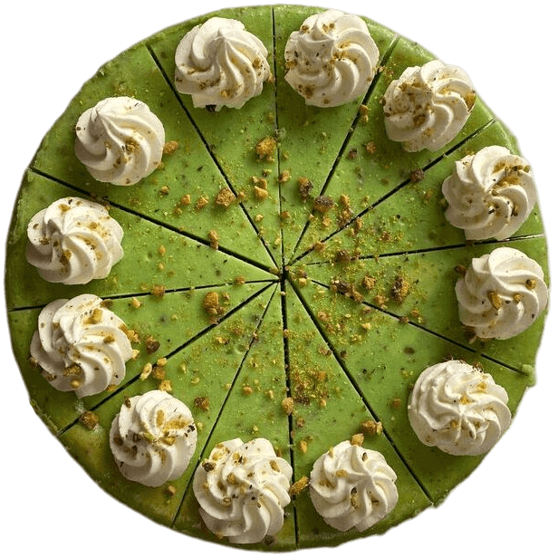 Green frosted cake cut into slices, topped with whipped cream swirls around the edge.