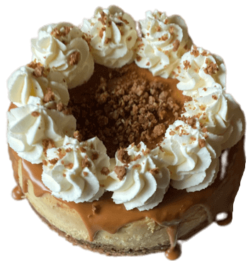 Caramel donut cake topped with whipped cream rosettes and crumb topping on a white background