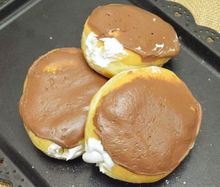 Three white chocolate bismarks with white cream fill