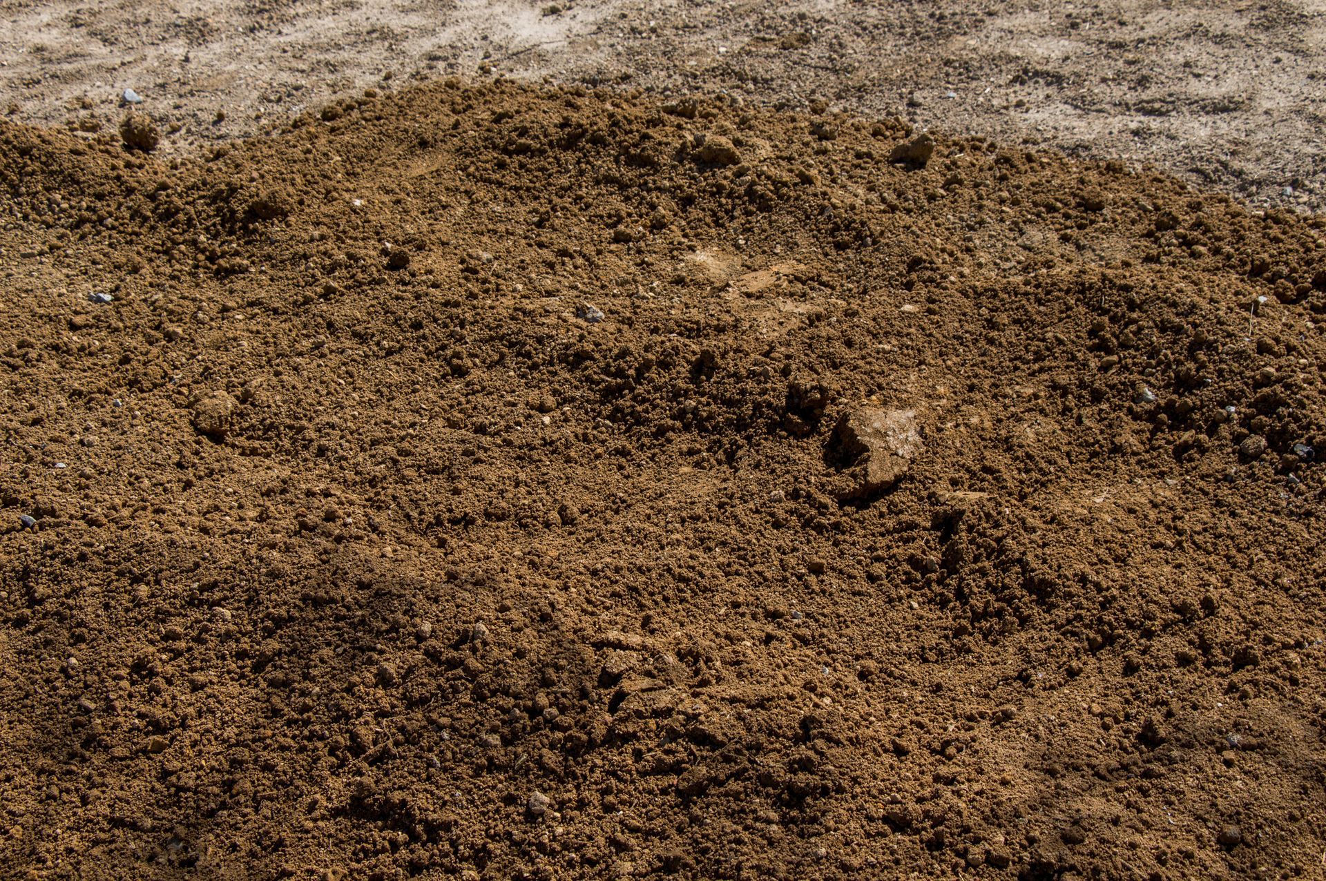 A pile of dirt is sitting on top of a concrete surface.