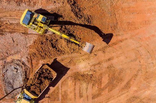 An aerial view of a construction site with a bulldozer and a dump truck.