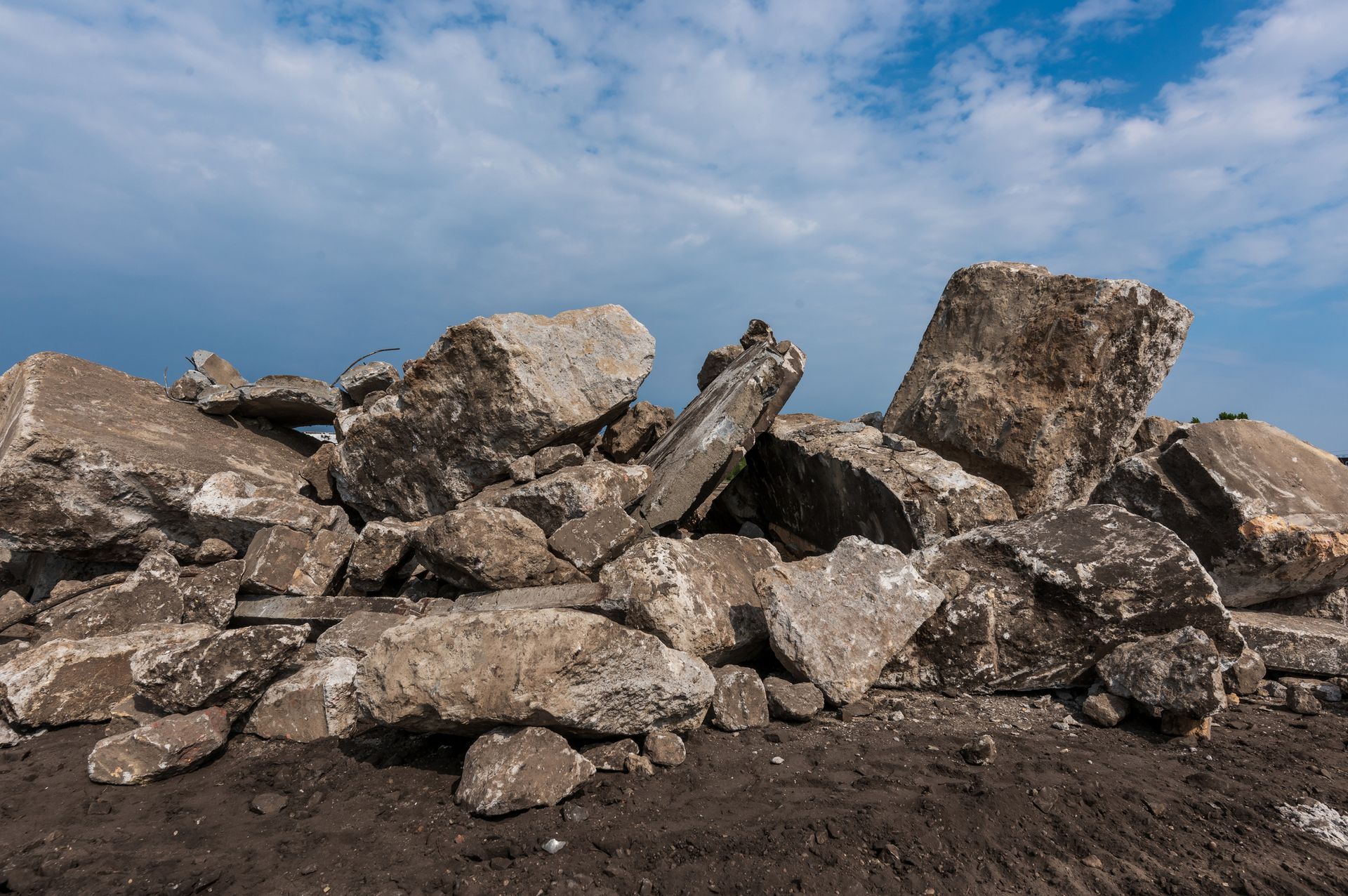 A pile of rocks in the dirt with a blue sky in the background A pile of rocks in the dirt with a blue sky in the background