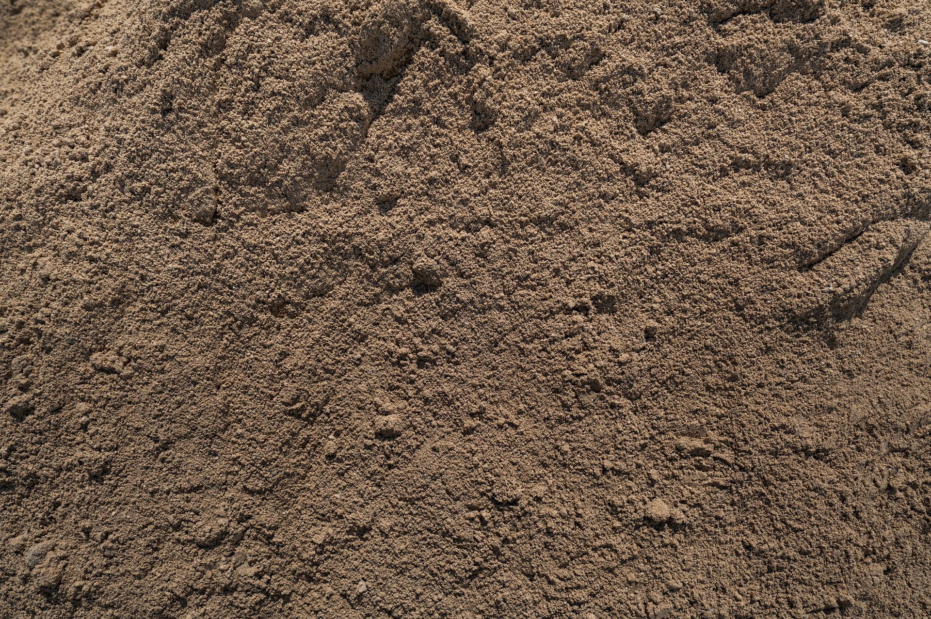 A close up of a pile of brown sand.