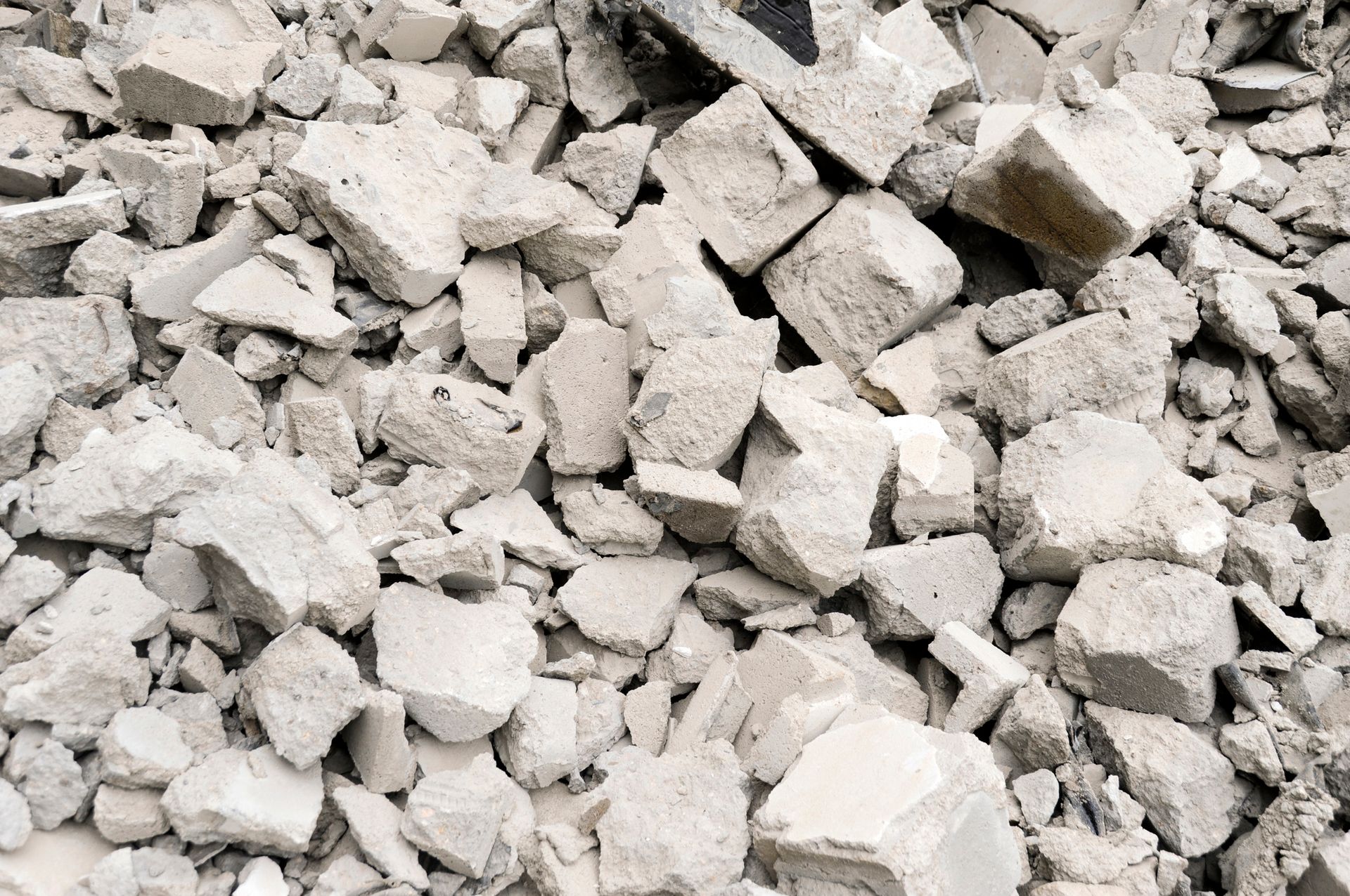 A pile of broken bricks is sitting on the ground. A pile of broken bricks is sitting on the ground.