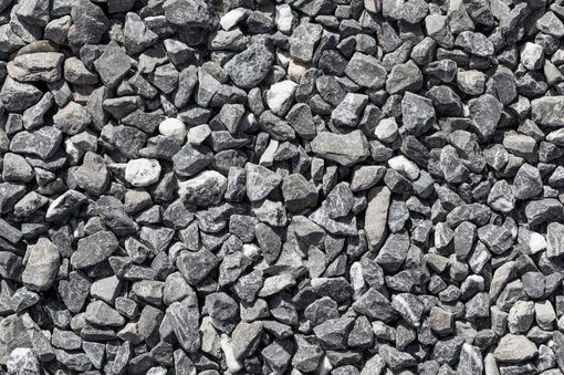 A pile of black gravel is sitting on the ground.