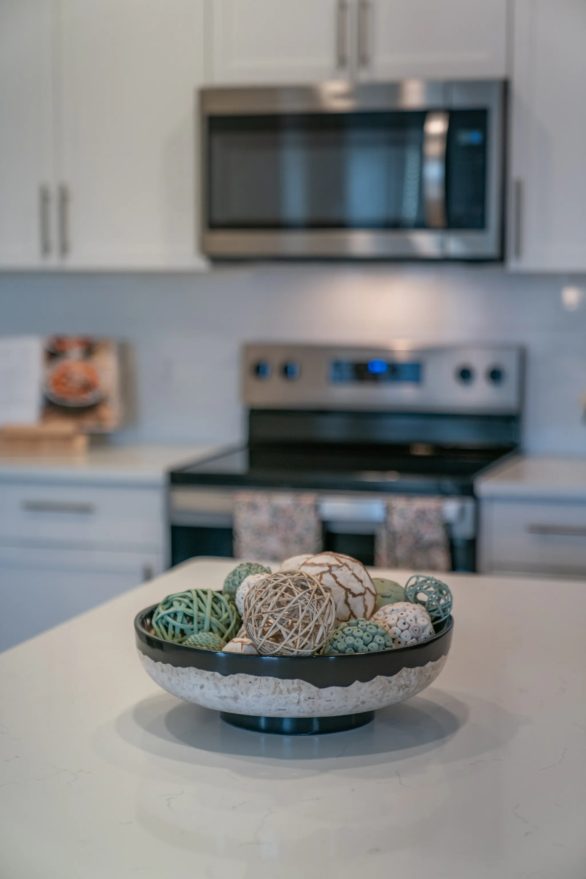 Decorated bowl of decorative orbs on a kitchen counter.