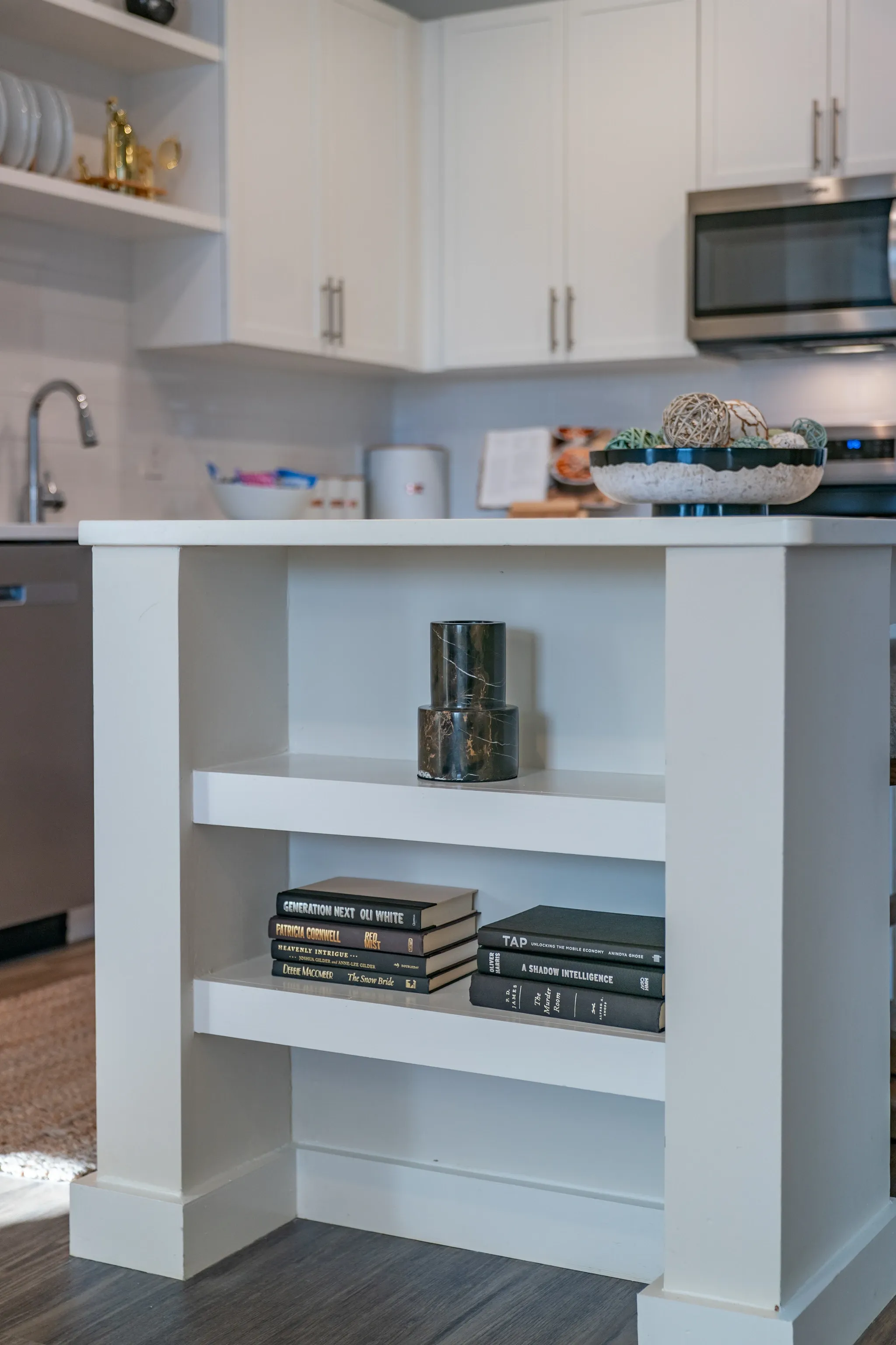 Modern white kitchen island with decorative items and books.