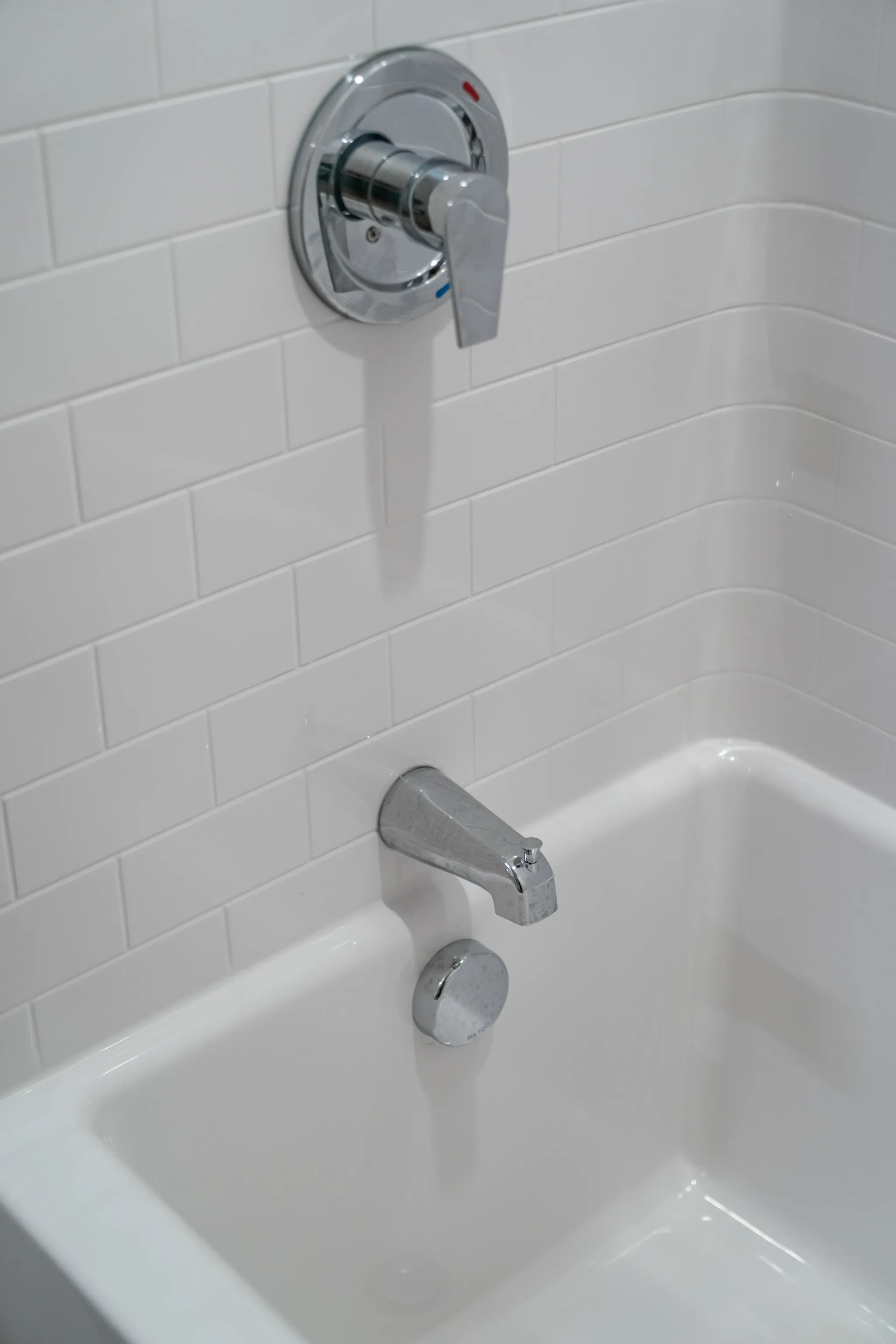 Close-up of a modern bathtub faucet and shower controls.