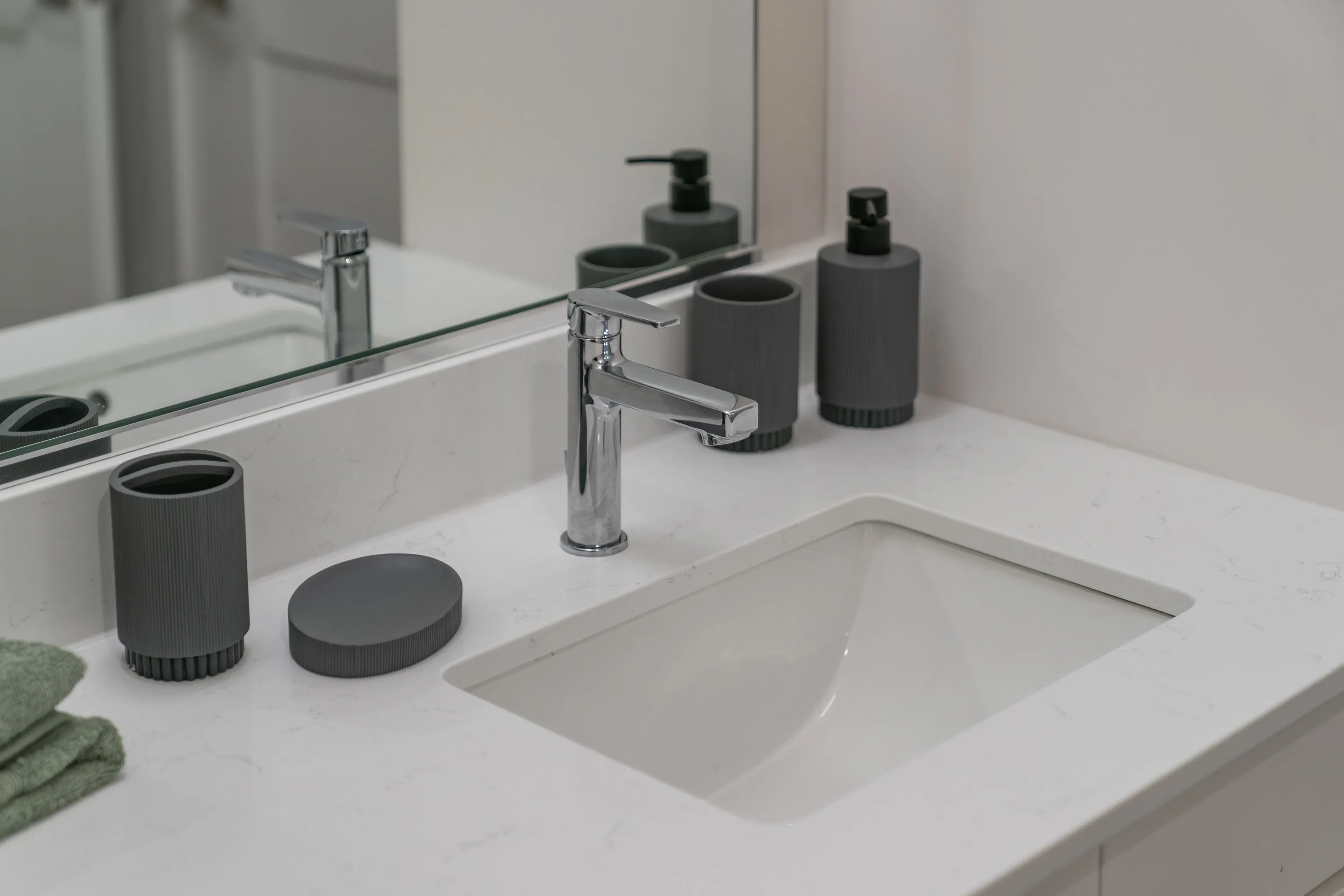 Modern bathroom vanity with a white countertop, sink, and chrome faucet.