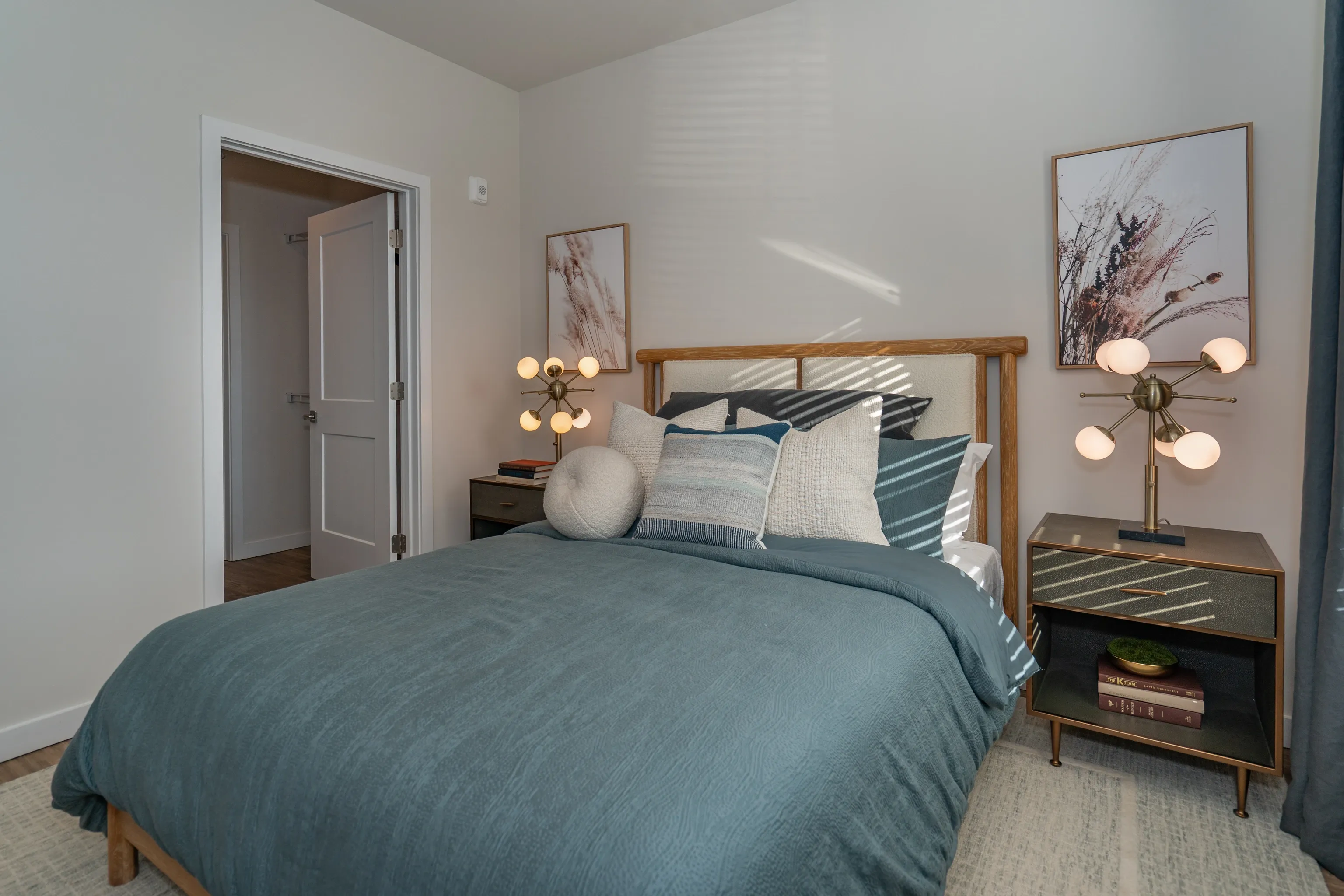 Bedroom with a queen-size bed, nightstands, and artwork.