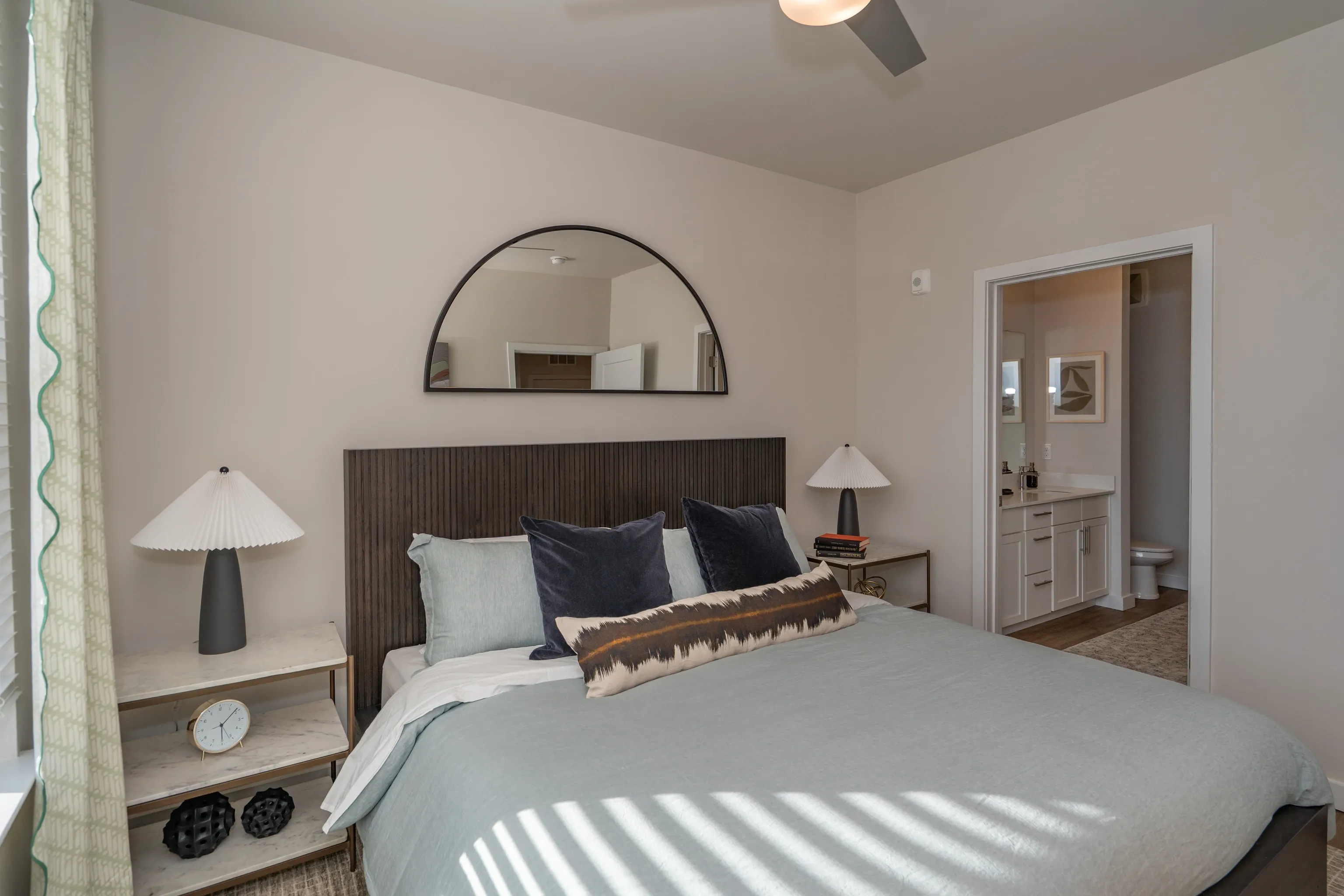 Primary bedroom with a queen-size bed, nightstands, and a glimpse into the bathroom.