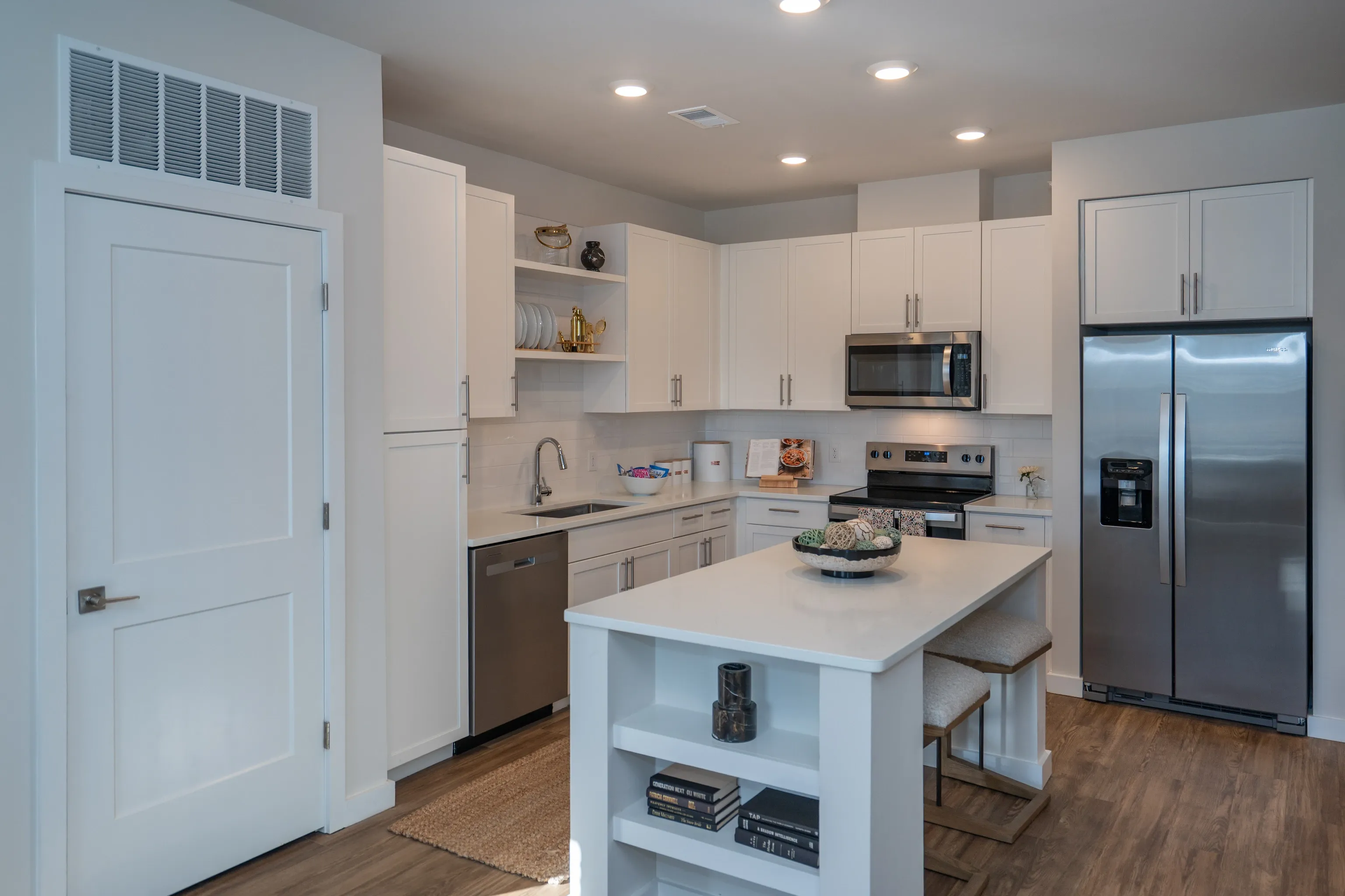 Modern kitchen with white cabinets, stainless steel appliances, and an island.