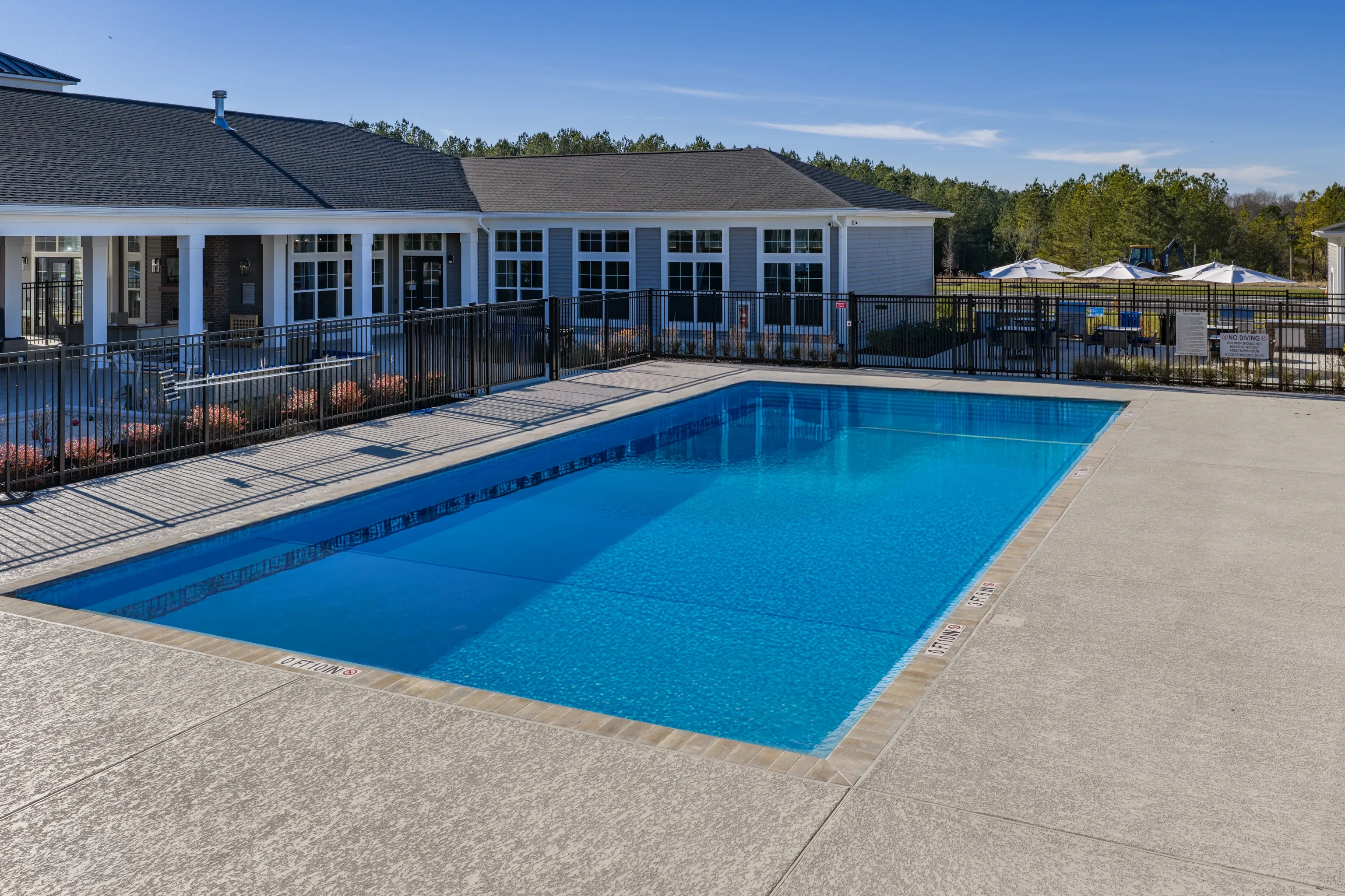 Outdoor swimming pool with lounge chairs and umbrellas.