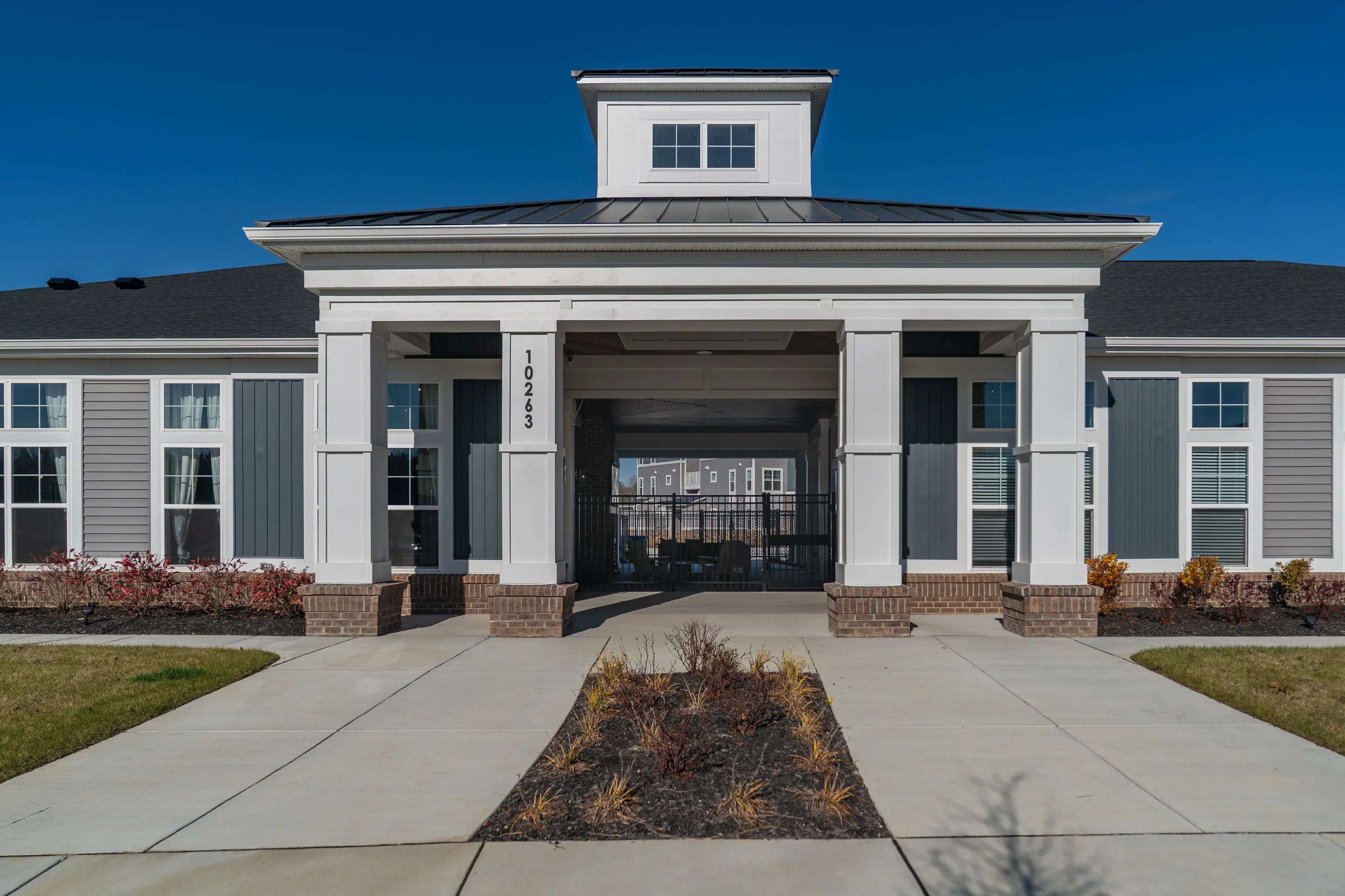 Exterior of a modern apartment building with a covered walkway and columns.