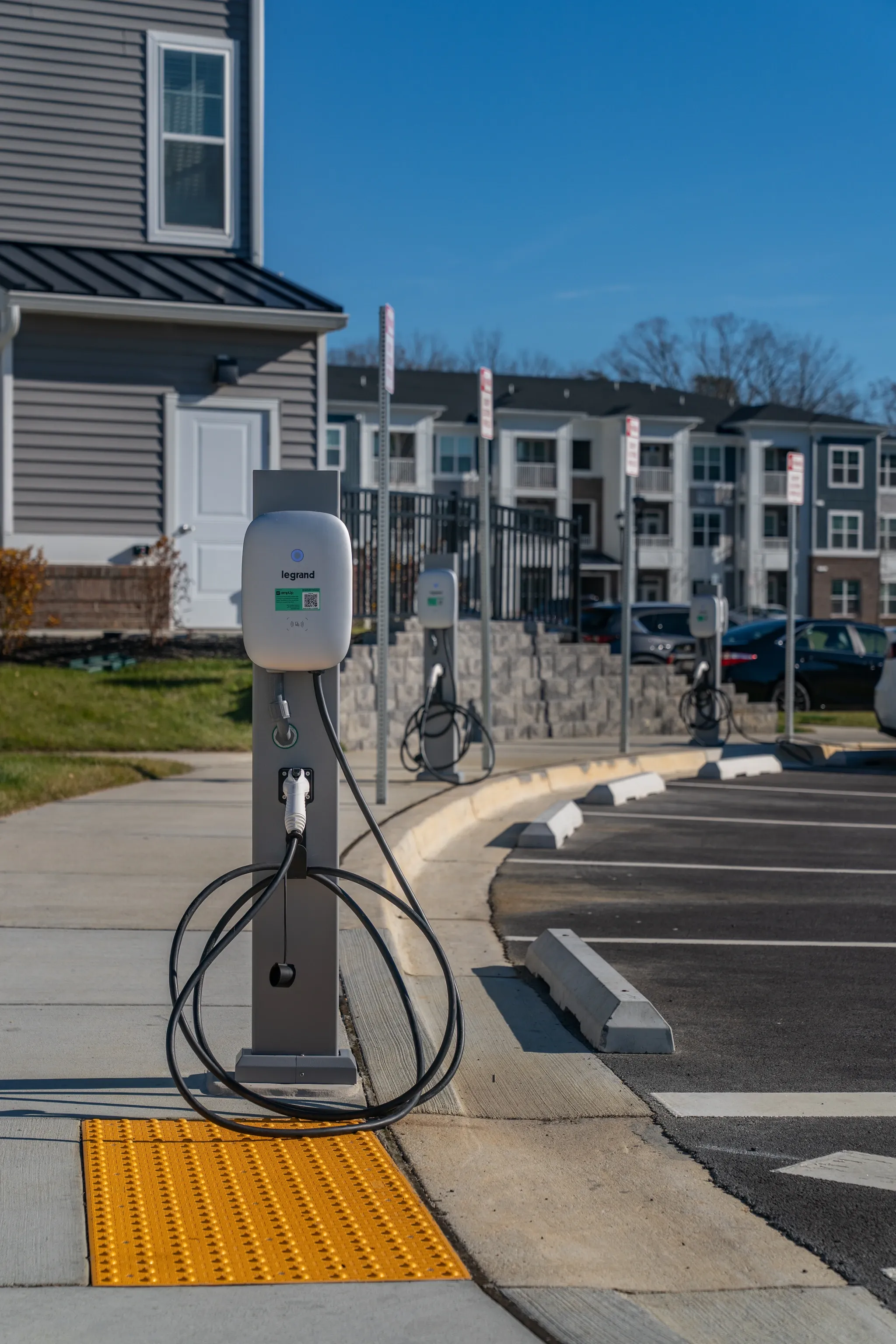 Electric vehicle charging stations at apartment complex parking lot.