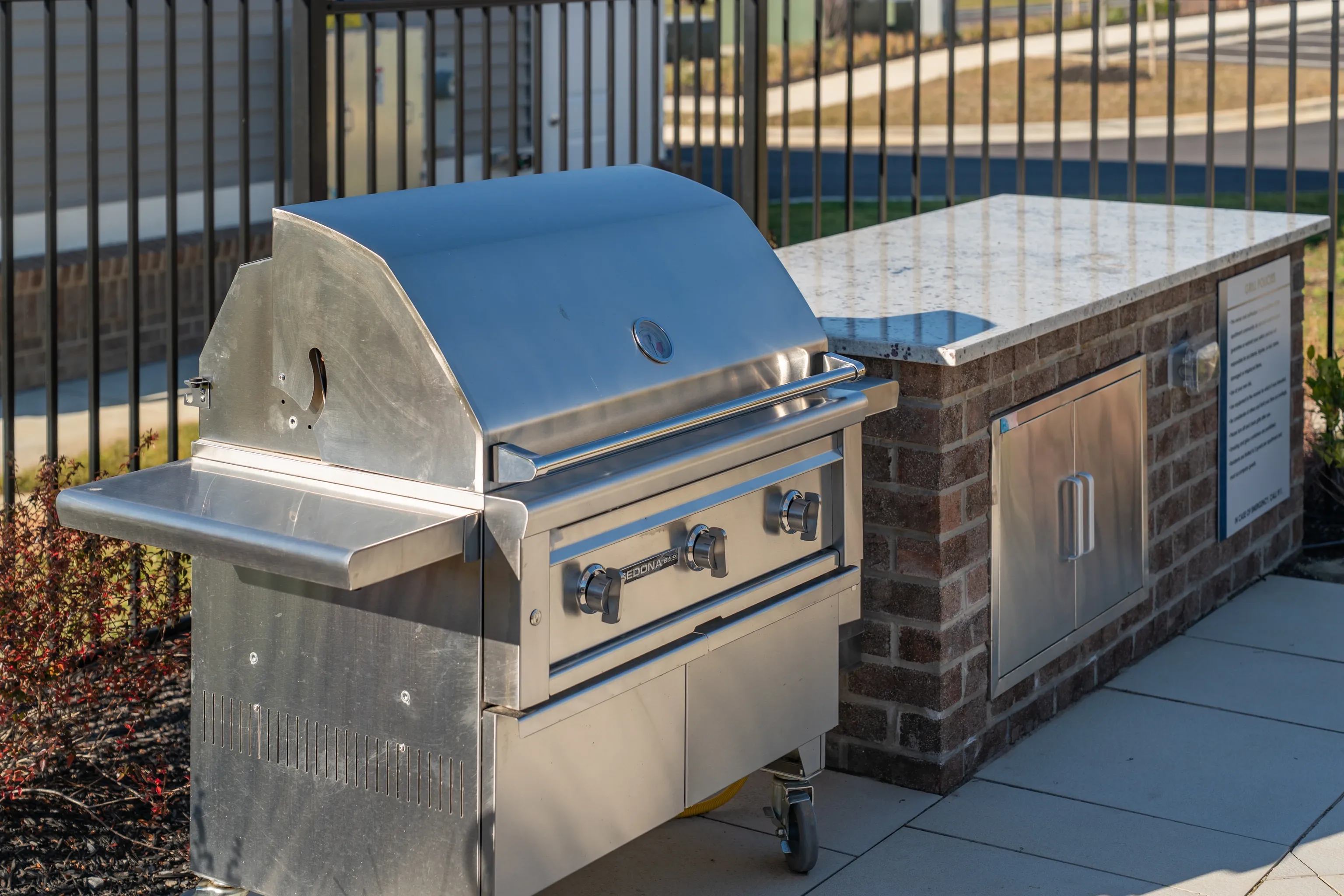 Outdoor stainless steel grill with granite countertop and brick base