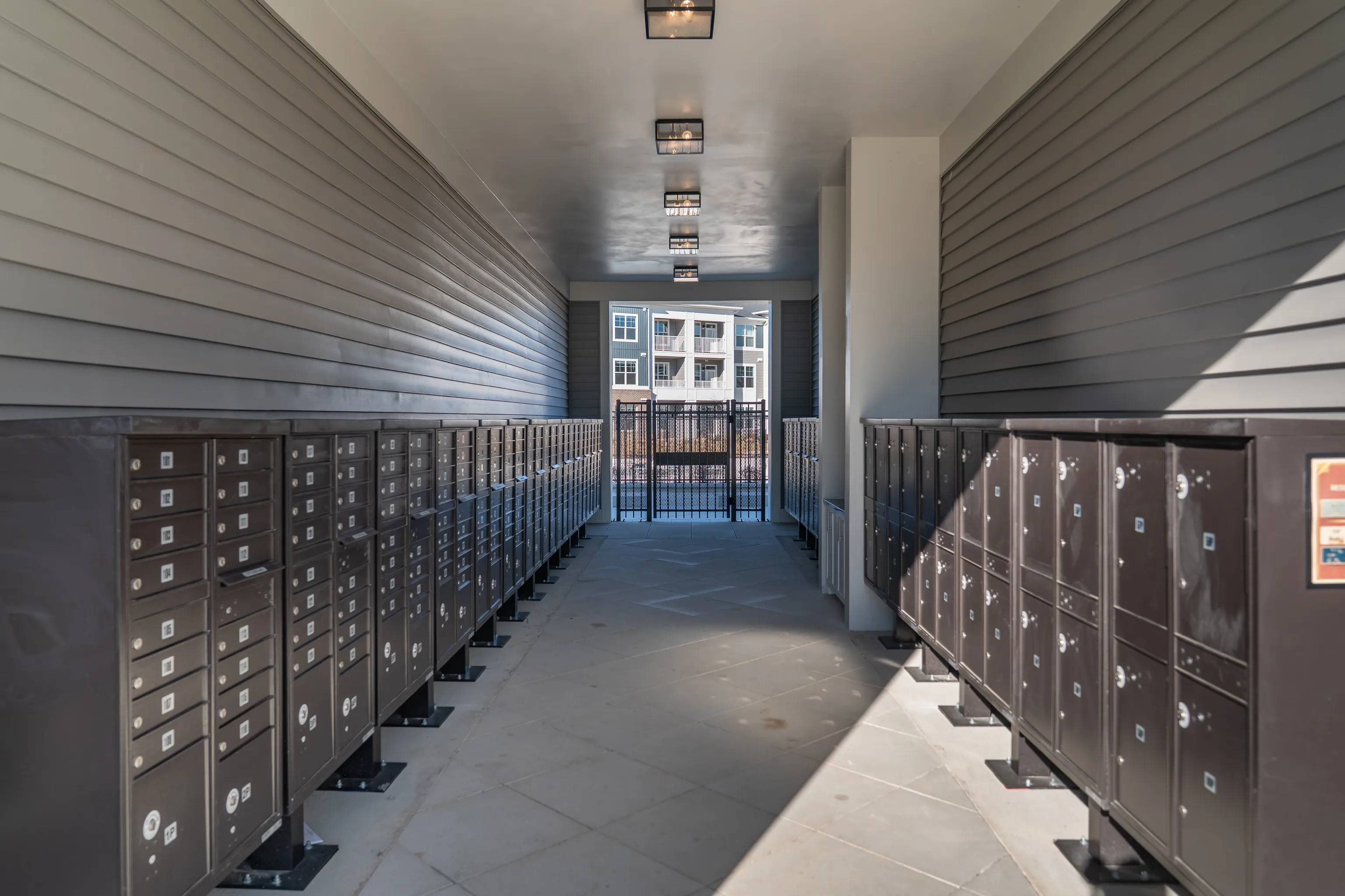 Mailboxes in a covered walkway leading to a building entrance.