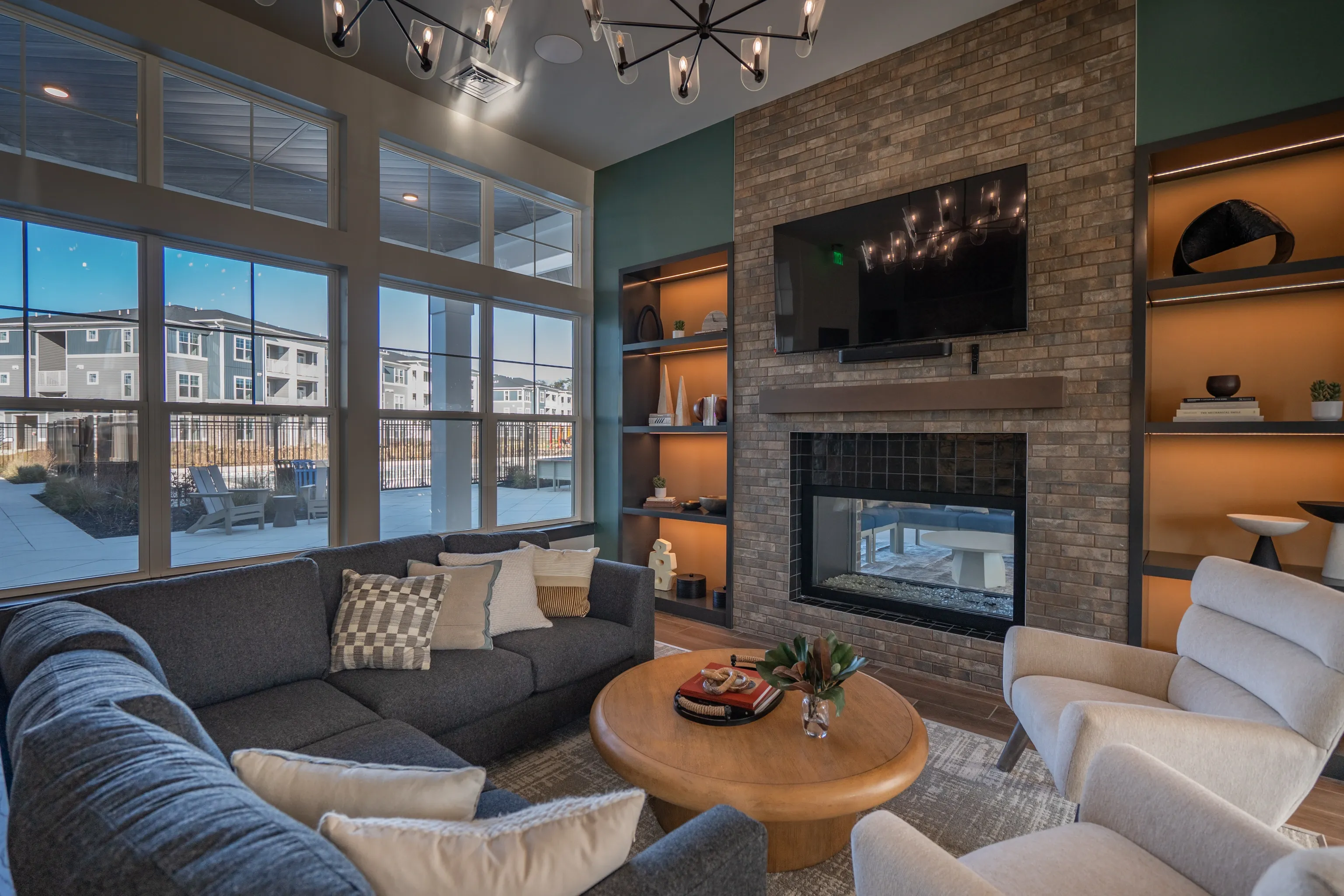 Modern apartment community lounge with fireplace and large windows overlooking the courtyard.