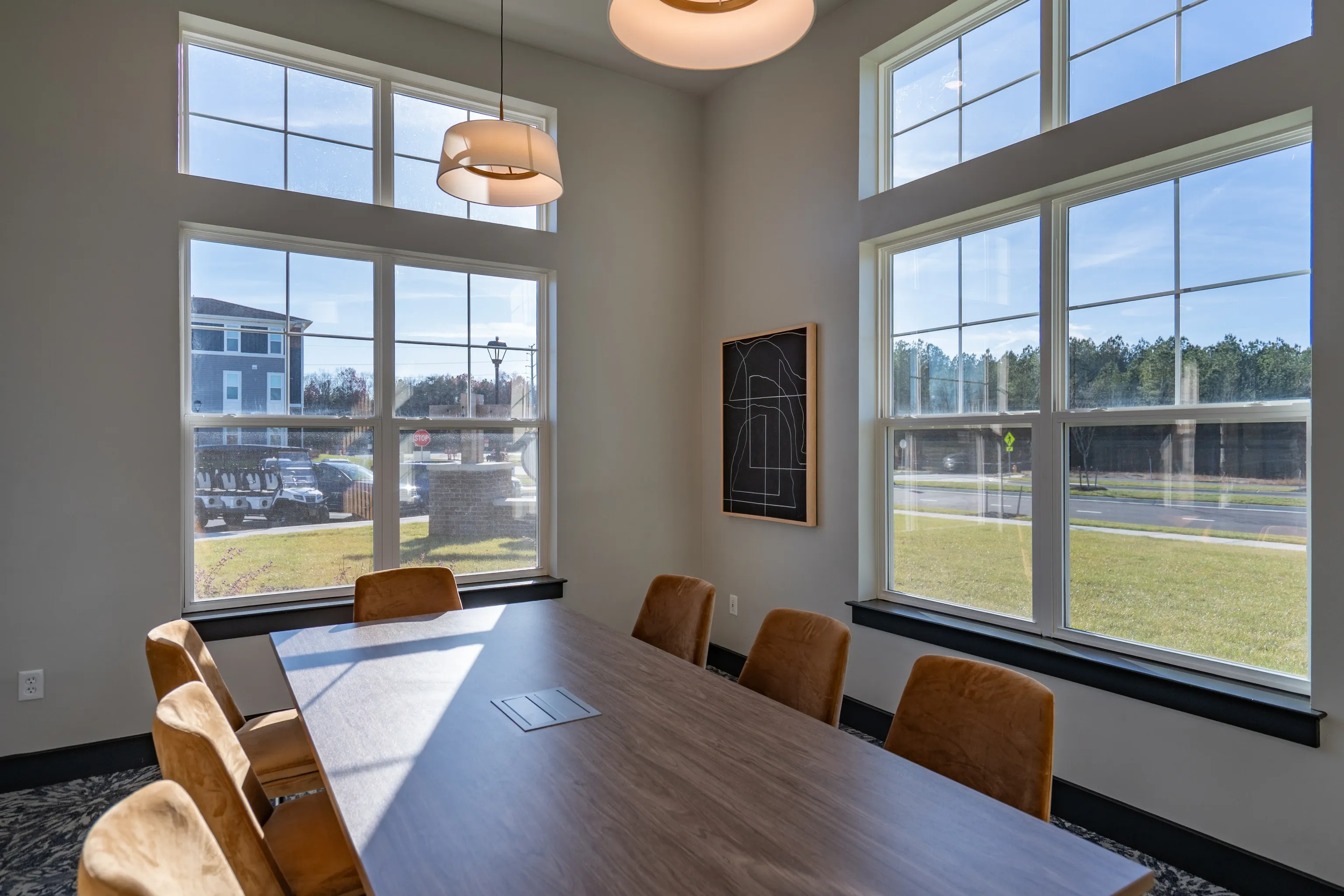 Conference room with large table and chairs, overlooking the exterior grounds.